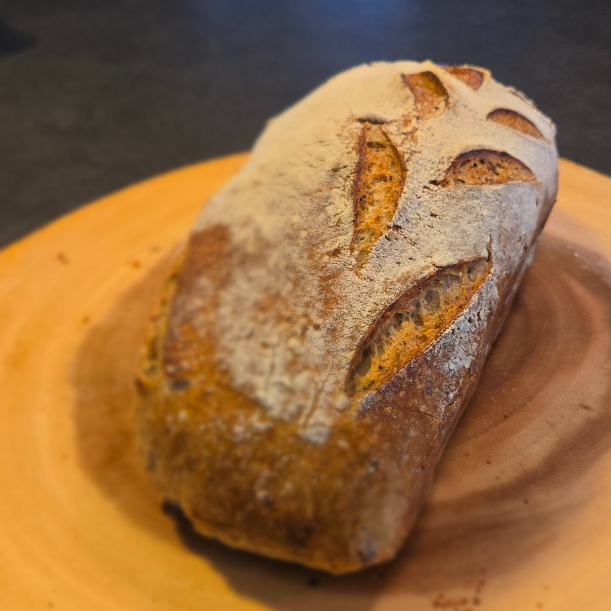 Loaf of bread on a wooden board with a dark background